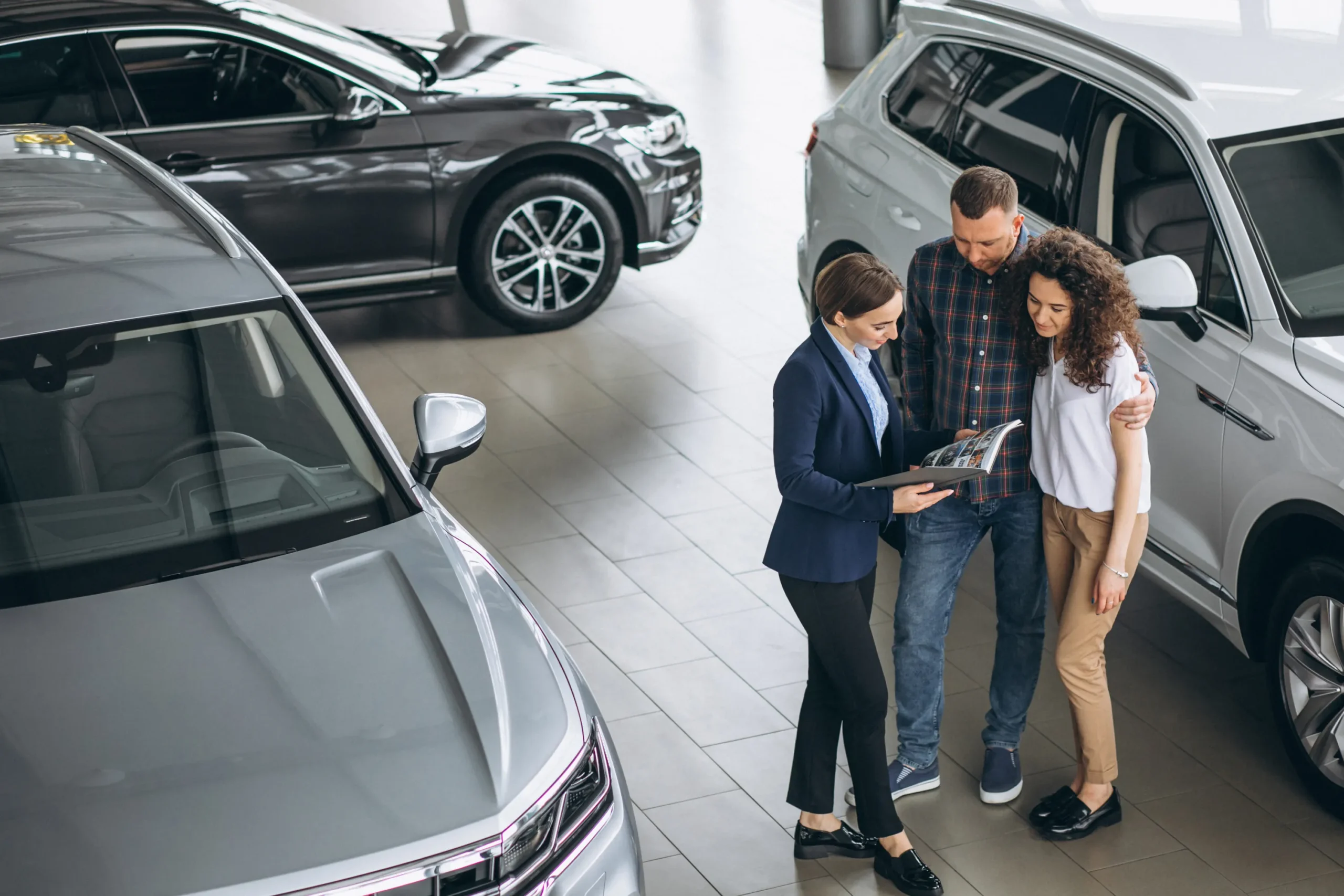 young-couple-talking-sales-person-car-showroom